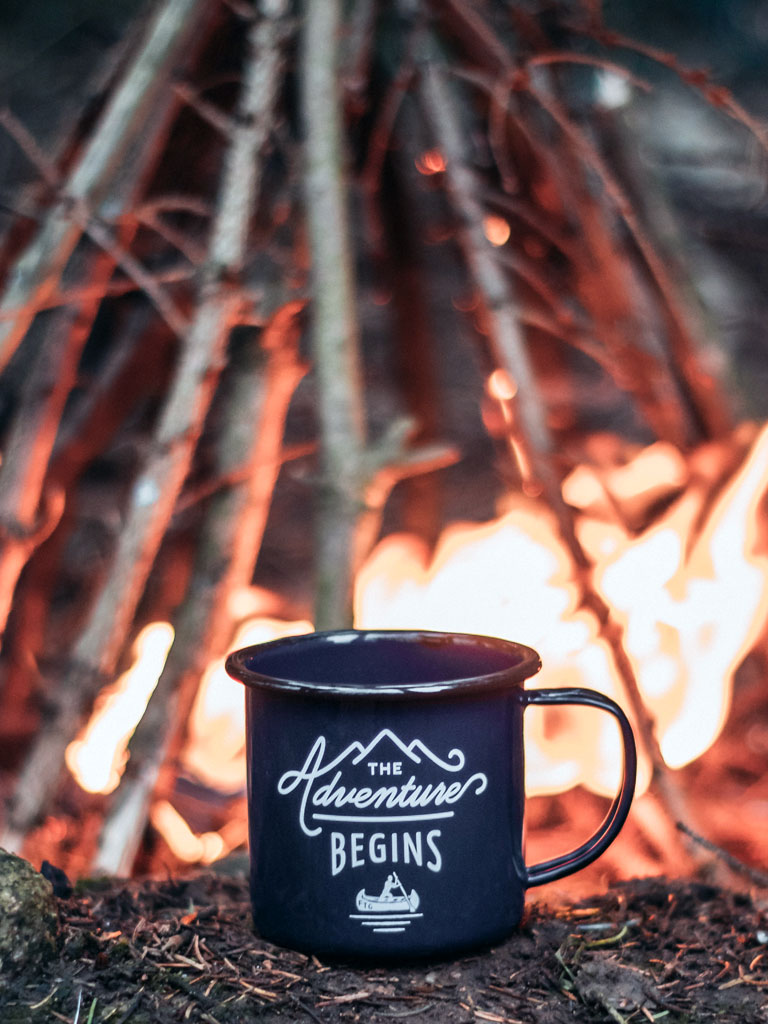 cup by the campfire, where adventure begins