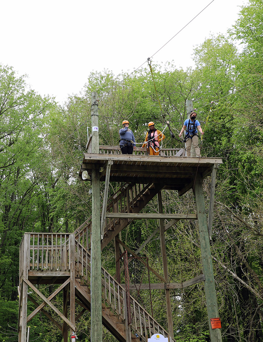 High ropes and zip lines with Deep Water Ministries. A group of women wait high on the platform to zip down